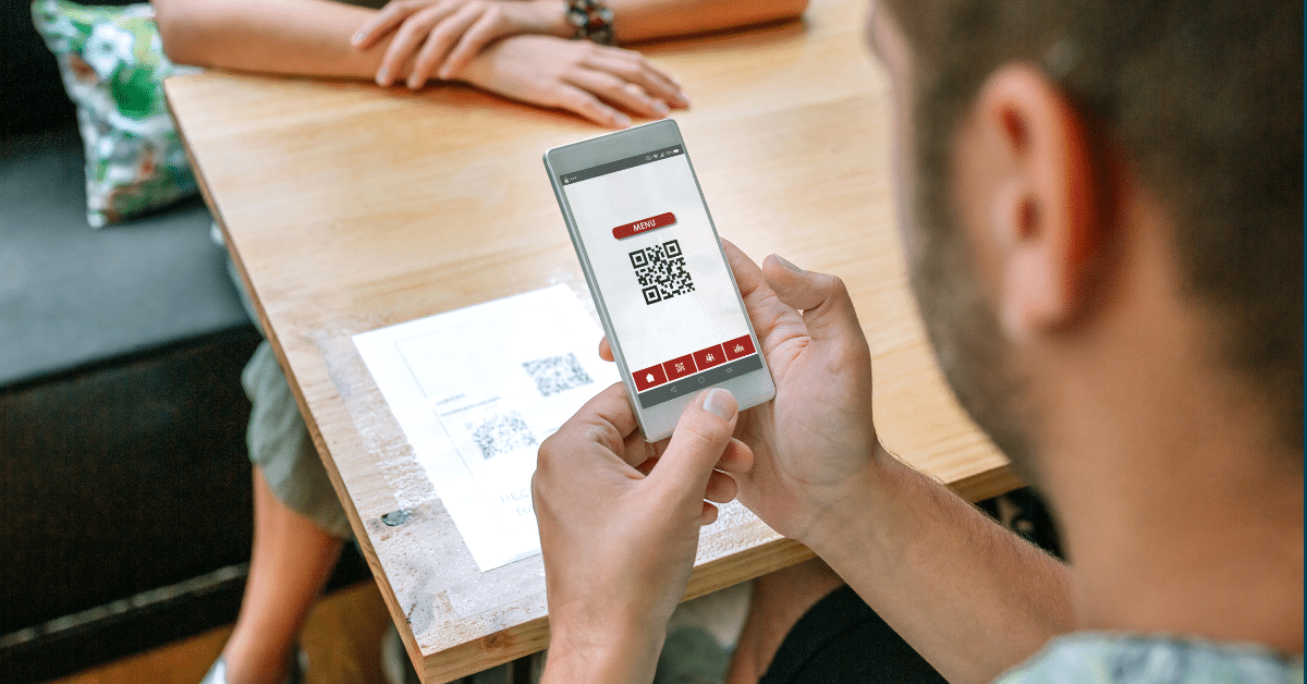 Blog header image of man with a phone in his hand scanning a QR code