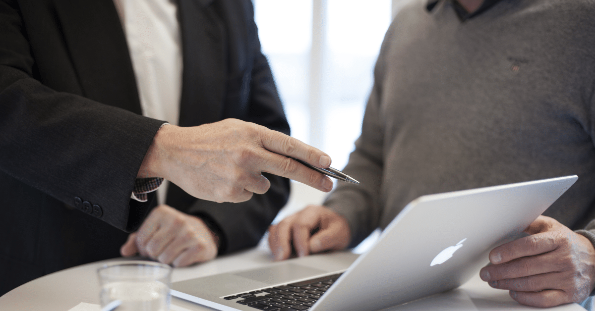 Blog header image of the hands of two people, one of whom is pointing to the screen