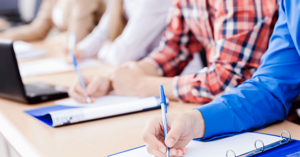 Blog header image with close up of hands, notebooks and a laptop